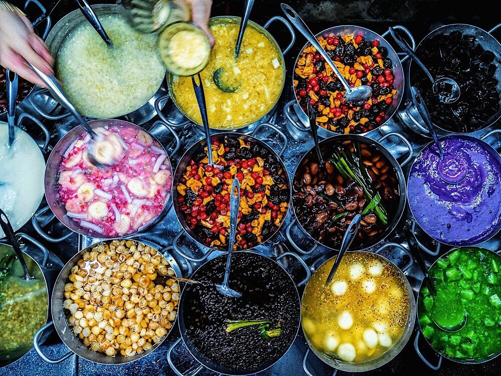 위에서 내려다본 후에 쩨 가게의 냄비들. 콩, 연밥, 타피오카 경단, 젤리, 색색의 푸딩이 담겨 있고 냄비마다 국자가 꽂혀 있다